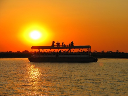 Sunset over tourist boat on Chobe River, Botswanaの写真素材