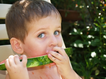 Baby eat watermelon in gardenの写真素材
