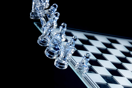 Falling Glass Chess Pieces on a Glass Chess Boardの写真素材
