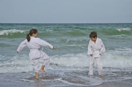 Kids practicing Aikido on the beach. Healthy lifestyle and sports conceptの写真素材