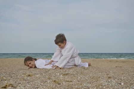 Kids practicing Aikido on the beach. Healthy lifestyle and sports conceptの写真素材