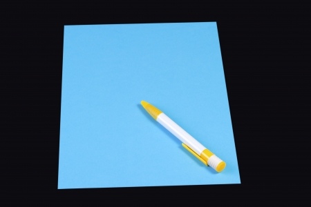 Pen on blue paper isolated on a black backgroundの写真素材