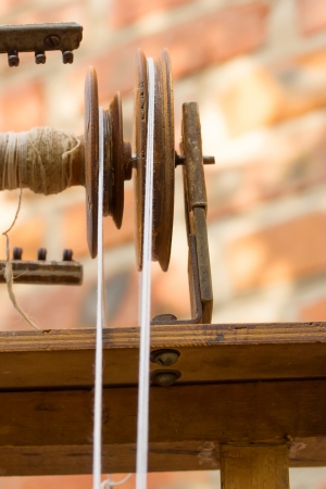 Distaff element close-up  Wool yarn passes through the pulleyの写真素材
