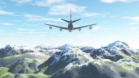 The plane flies over the snow-capped mountains beyondの写真素材