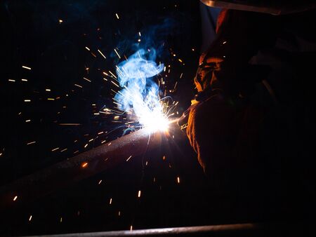 Electric welding works on the pipeline in a dark room