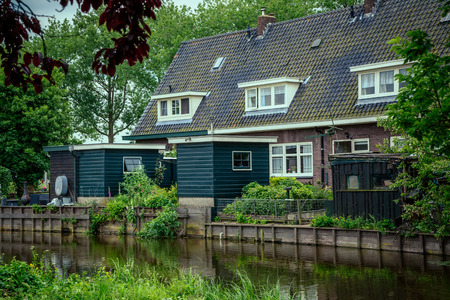 old house with attic Windows which stands on the riverの写真素材