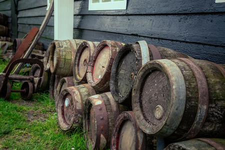 old oak barrels of beer were piled lie near the House