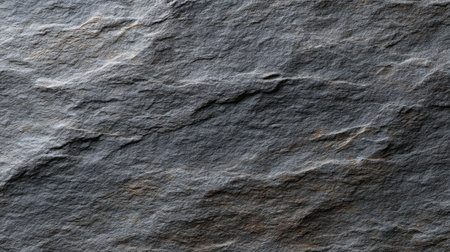 This image features a close-up view of a rugged gray stone surface, highlighting intricate textures and patterns ideal for backgrounds in creative projects.の素材