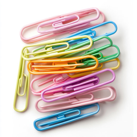 A vibrant collection of colorful paper clips arranged casually on a white backdrop. Perfect for office supplies, school projects, and creative uses.の素材