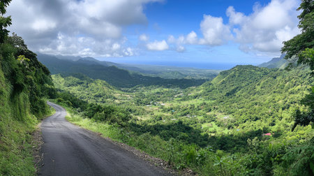 Panoramic view of an asphalt road disappearing into the horizon, winding through a verdant valleyの素材