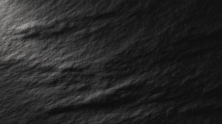 This image features a dark textured background showcasing subtle waves and creases, ideal for creative design projects, photography, or artistic expressions.の素材