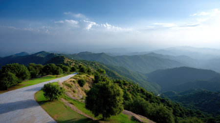 Experience the serene beauty of a winding road leading to expansive mountain views under a clear sky. Embrace nature's tranquility and charm.の素材
