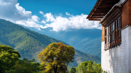 Capture the serene beauty of traditional Bhutanese architecture framed by majestic mountains under a vibrant blue sky, showcasing nature's splendor.の素材