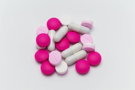 Prescription drugs, pills, capsules and tablets of different colors all mixed in. On white background.の写真素材