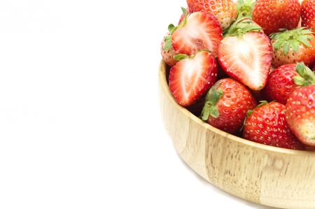 Strawberries in wooden bowl isolated on white background.の写真素材