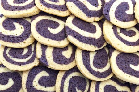 Cookies in the shape of a spiral pattern close-up on full frame background. Handmade biscuits. の写真素材