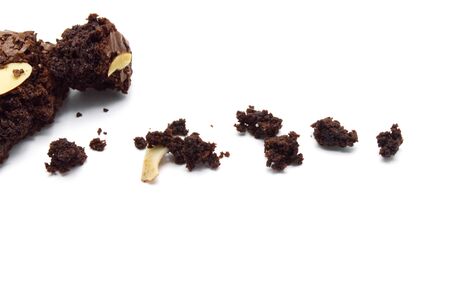 Crumble of chocolate brownies with sliced almond nuts toppings isolated on white background.