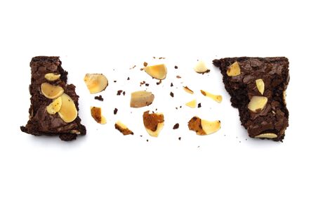 Chocolate brownies with sliced almond nuts toppings broken and crumbs isolated on white background. の写真素材