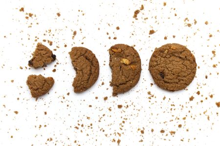 Cookies with chocolate chip flavored. Some broken and crumbs of crunchy delicious sweet meal and useful biscuits on white background.の写真素材