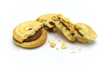 Sandwich cookies filled with coffee cream flavored. Some broken and crumbs of crunchy delicious sweet meal and useful cookie on white background.の写真素材