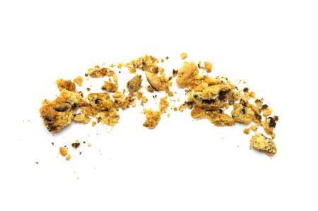 Scattered crumbs of homemade oatmeal raisin cookies isolated on white background.の写真素材
