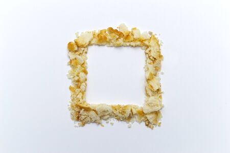 The shape of a square lined with crumbs from cookies on white background. Copy space.の写真素材