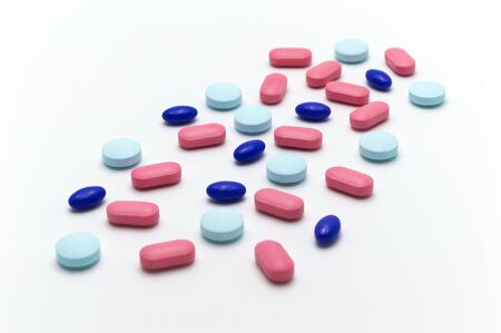 Many different medical pills on white background. Selective focus.