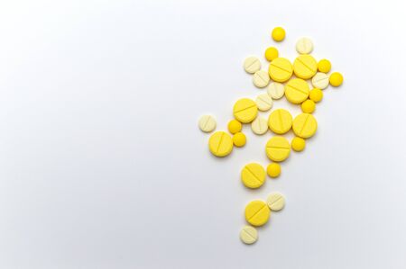 Prescription drugs or medicine pills and tablets of yellow colors shades. On white background. Top view.の写真素材