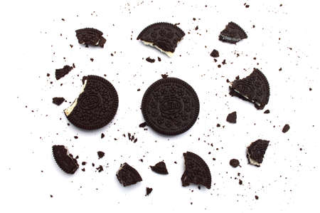 Oreo Biscuits with broken and crumbs isolated on white background. It is a sandwich chocolate...