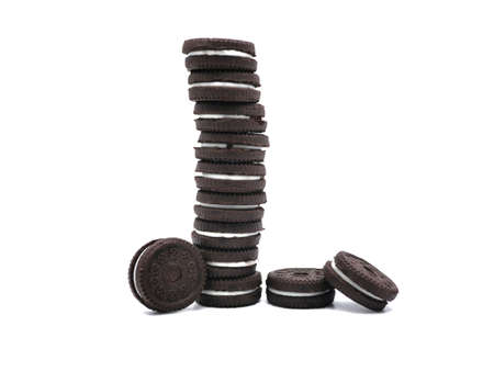 Stack of sandwich chocolate cookies with a sweet cream isolated on white background.