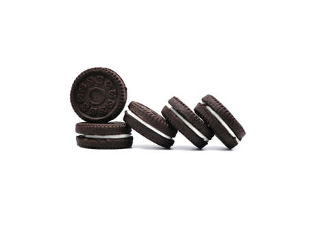 Stack of sandwich chocolate cookies with a sweet cream isolated on white background.の写真素材