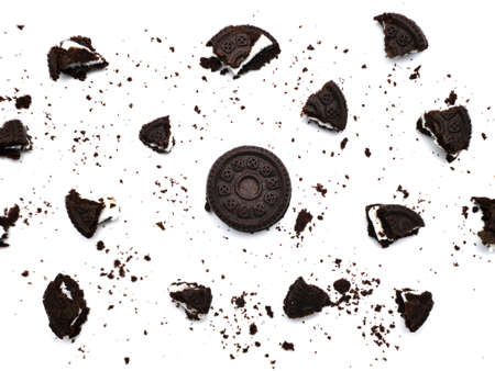 Sandwich chocolate cookies with a sweet cream with crumbs isolated on white background.の写真素材