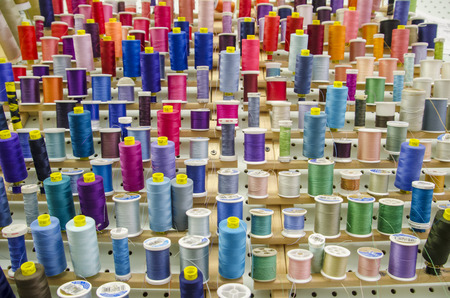 Display of assorted colored thread on spoolsの写真素材