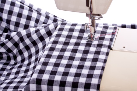 a sewing machine with black and white checked modern fabric isolated over white