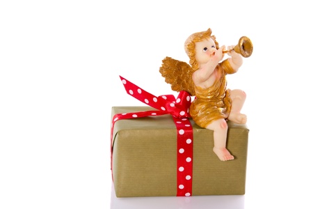 a musical angel on top of a present isolated on white backgroundの写真素材