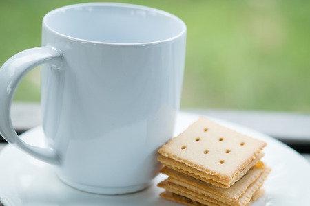 Cup of milk with crackers on a plateの写真素材