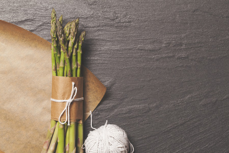 Asparagus tied in a bunch on a rustic backgroundの写真素材