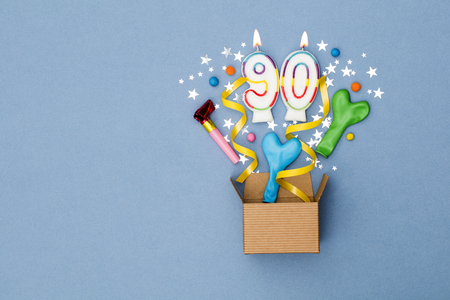 Number 90 celebration present background. Gift box exploding with party decorationsの写真素材