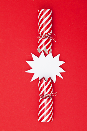 Popped Christmas crackers on a red backgroundの写真素材