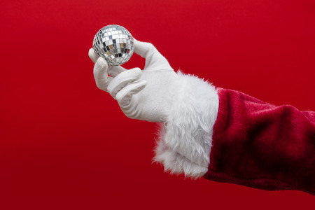 Santa Claus hand holding a glitter disco ballの写真素材