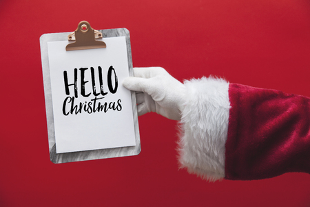 Santa Claus hand holding a clipboard with Christmas message pageの写真素材