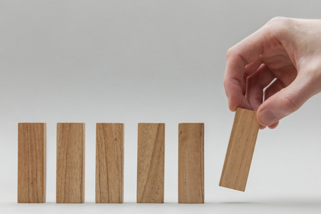 Male hand stacking wooden blocks in a line. Business development and growth conceptの写真素材