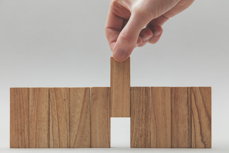 Male hand stacking wooden blocks in a line. Business development and growth conceptの写真素材