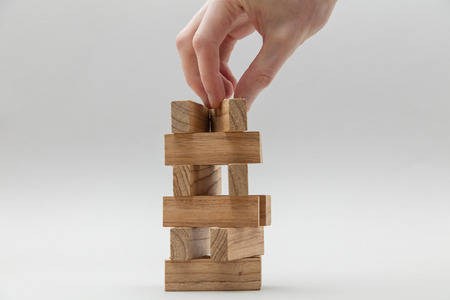 Male hand stacking wooden blocks. Business development and growth conceptの写真素材