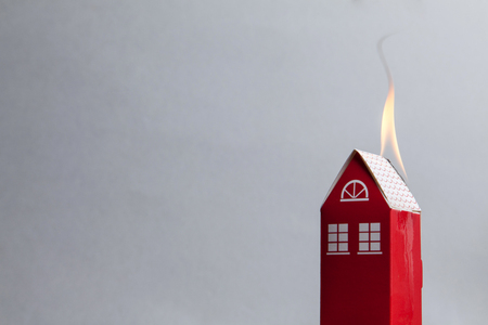 House fire concept. Toy house with flamesの写真素材