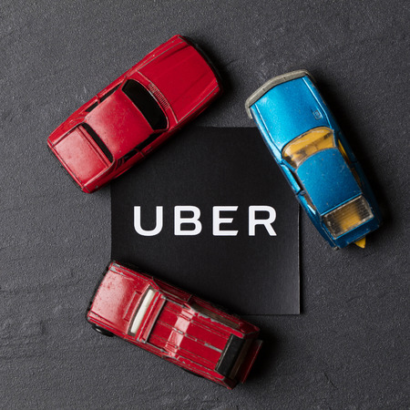 A photograph of  the Uber logo and toy car. Uber is a popular taxi style transport service application, founded in 2009のeditorial素材