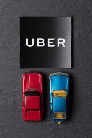A photograph of  the Uber logo and toy car. Uber is a popular taxi style transport service application, founded in 2009のeditorial素材