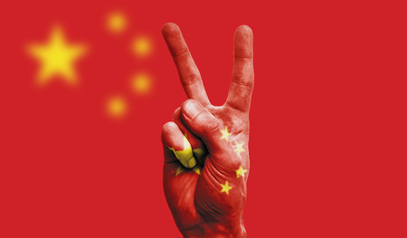 China national flag painted onto a male hand showing a victory, peace, strength signの写真素材