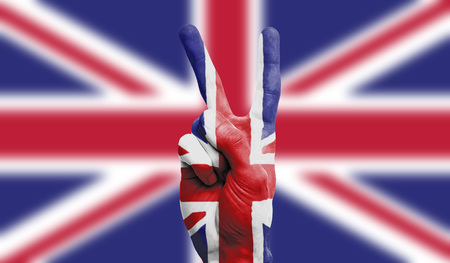 UK national flag painted onto a male hand showing a victory, peace, strength signの写真素材
