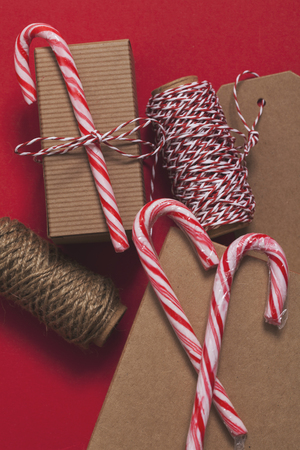 Festive Christmas present with candy cane on a red backgroundの写真素材